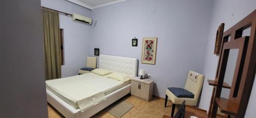 a small bedroom with a bed and a chair at Jon rooms in Himare
