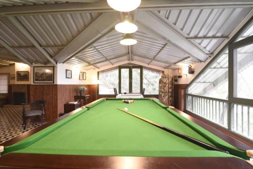 a pool room with a green pool table at 7 Pines Kasauli in Kasauli