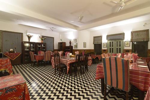 a restaurant with tables and chairs in a room at 7 Pines Kasauli in Kasauli