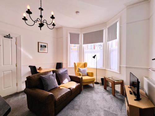 - un salon avec un canapé et une chaise dans l'établissement Fernhurst holiday apartments, à Shanklin