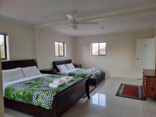 a bedroom with two beds and a couch at Tuggeranong Short Stay #11C - Sleeps 8 in Canberra