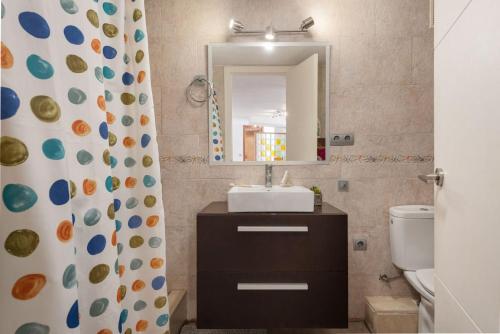 Un baño con lavabo, espejo e inodoro. en Apartment Lyon - Alcúdia - ETVPL15408, en Alcudia