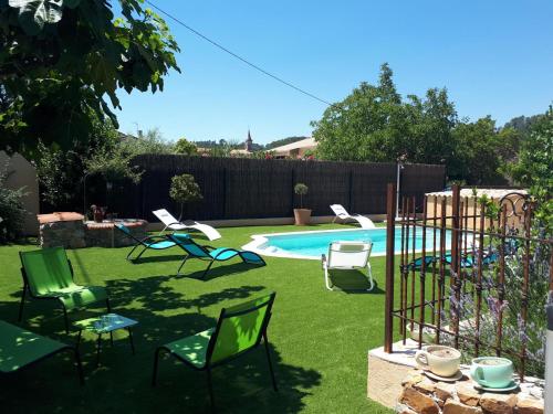 une cour avec des chaises et une piscine dans l'établissement Gîte Maison provençale Coeur du Var (rez-de-chaussée), à Gonfaron