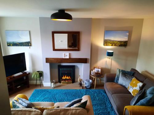 a living room with a couch and a fireplace at Coddiwomple in Leyburn