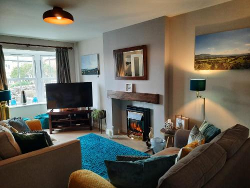 a living room with a couch and a fireplace at Coddiwomple in Leyburn
