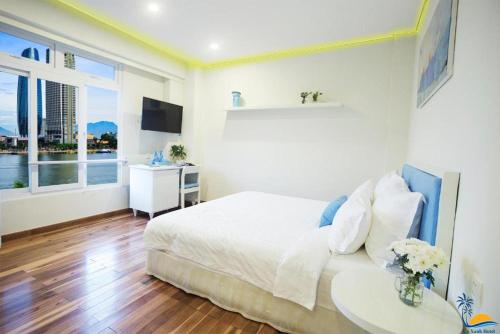 een slaapkamer met een bed, een tafel en een raam bij Cọ Xanh Hotel in Da Nang