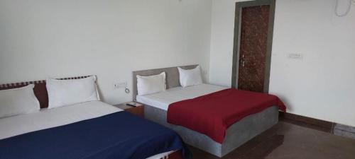 duas camas num pequeno quarto com duas camas sidx sidx em Saritashray Seva Dham em Vrindavan