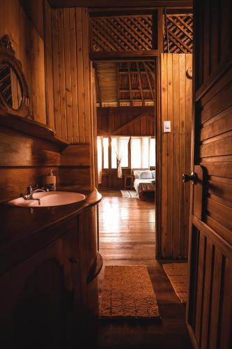 a bathroom with a sink and a room with a bed at Ocean Forest Ecolodge in San Pedrillo