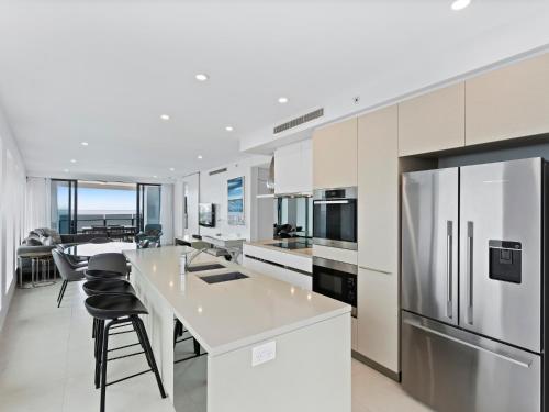 a white kitchen with a large island and appliances at Soul Beachfront Apartments - Hosted by Coastal Letting Co. in Gold Coast