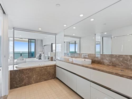 a bathroom with two sinks and two mirrors at Soul Beachfront Apartments - Hosted by Coastal Letting Co. in Gold Coast