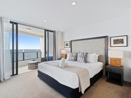 a bedroom with a large bed and a balcony at Soul Beachfront Apartments - Hosted by Coastal Letting Co. in Gold Coast