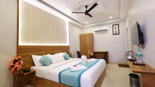 a hotel room with a bed and a ceiling fan at Hotel Grand Square in Yercaud