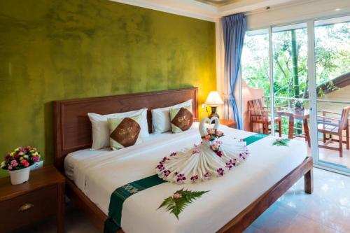 a bedroom with a bed with a dress on it at Baan Vanida Garden Resort in Karon Beach