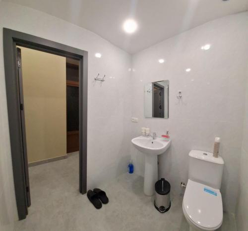 a bathroom with a white toilet and a sink at Al-Hilal Hostel in Samarkand