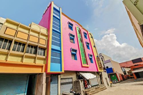 un edificio rosa con ventanas coloridas en una calle en OYO Suraj Residency, en Warangal