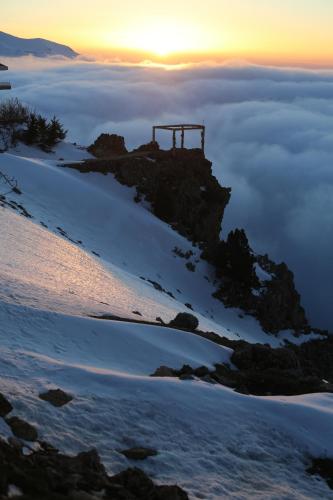 a building on top of a mountain above the clouds at Le Cedrus Hotel in Al Arz