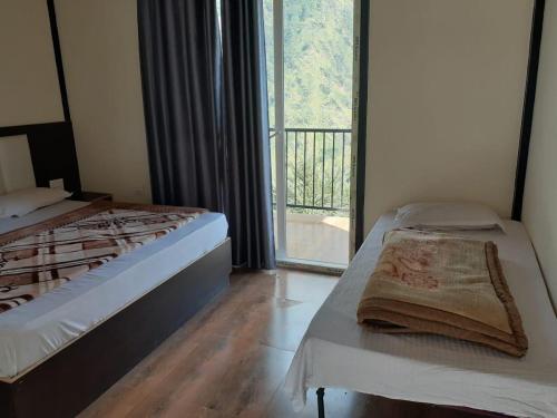 um quarto com uma cama e uma janela com uma varanda em Sitapur Dharmasala by prithvi yatra hotels em Gaurikund