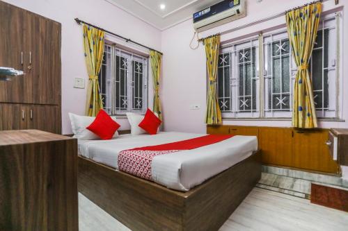 a bedroom with a bed with yellow and red pillows at OYO Ma Kali Guest House Near City Centre Salt Lake in Salt Lake City