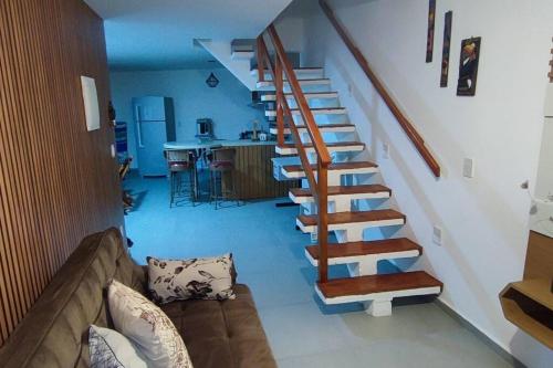 a spiral staircase in a living room with a couch at Casa de Veraneio na Praia do Francês in Marechal Deodoro