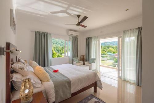 Schlafzimmer mit einem Bett und einem Deckenventilator in der Unterkunft Tropic Villa Annex in Grand'Anse Praslin