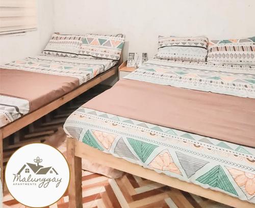 Een bed of bedden in een kamer bij Malunggay Apartments