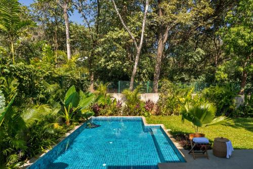 a swimming pool in a yard with trees at La Macedo, Luxury 3 BHK Villas in Assagao, with Private Pool, Garden, Terrace, Parking, Security in Mapusa