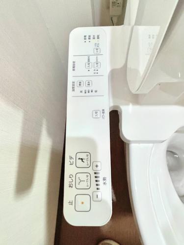 a control panel for a toilet in a bathroom at ホステル今鶴 ダブルルーム 301号室 in Osaka