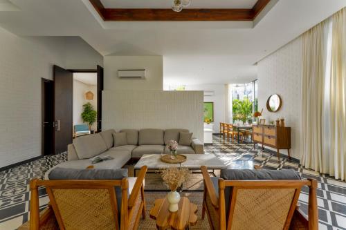 a living room with a couch and a table and chairs at La Macedo, Luxury 3 BHK Villas in Assagao, with Private Pool, Garden, Terrace, Parking, Security in Mapusa