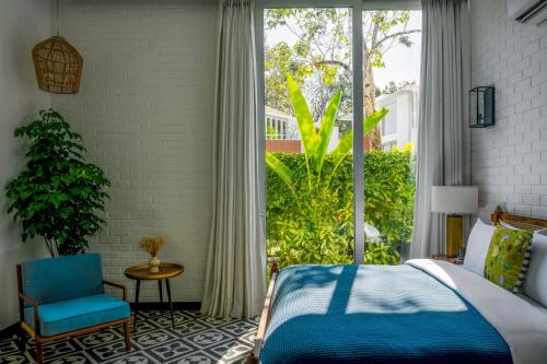 a bedroom with a bed and a large window at La Macedo, Luxury 3 BHK Villas in Assagao, with Private Pool, Garden, Terrace, Parking, Security in Mapusa