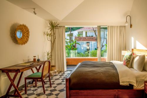 - une chambre avec un lit, un bureau et une fenêtre dans l'établissement La Macedo Estate, à Mapusa