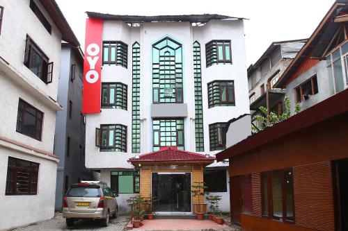 un edificio con un coche aparcado delante de él en OYO Hotel Azad, en Jammu