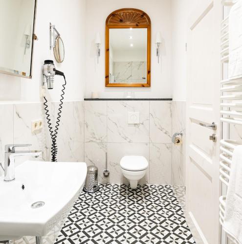 a white bathroom with a sink and a toilet at Kloster Hedersleben in Hedersleben