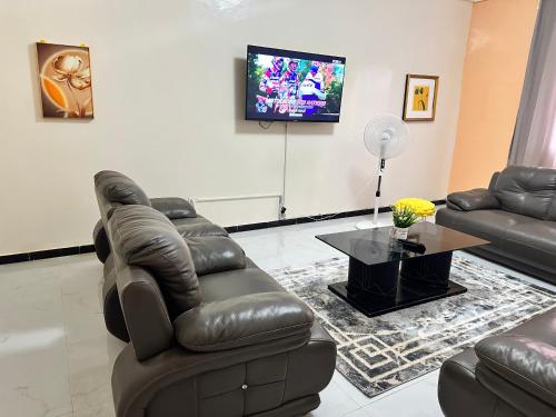 a living room with two couches and a flat screen tv at Résidences PRIMIS Thiès - appartements et chambres in Thiès