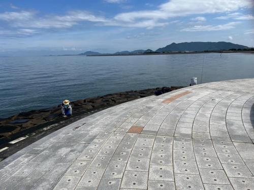 a person standing on the shore of a body of water at GuestHouse紫雲 -SHIUN- in Toyohama