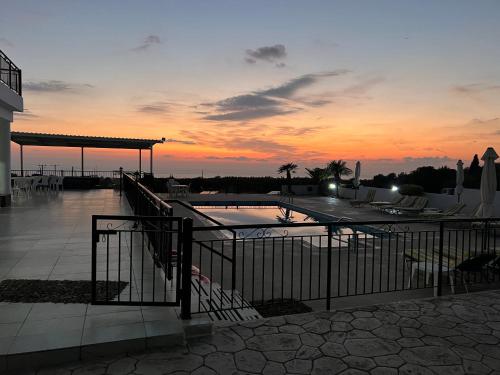 a sunset over a swimming pool at a resort at Nayia Paradise Villa! Best Villa in Cyprus in Paphos City