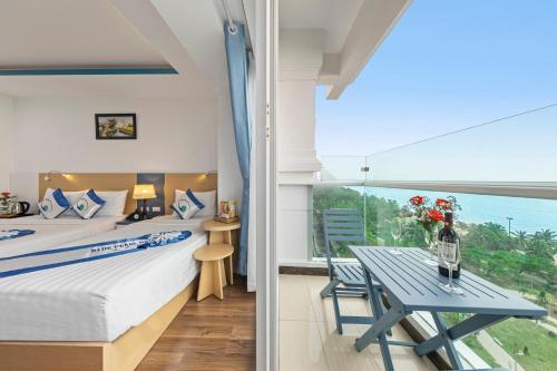 1 dormitorio con cama, mesa y ventana en Blue Pearl Hotel, en Nha Trang
