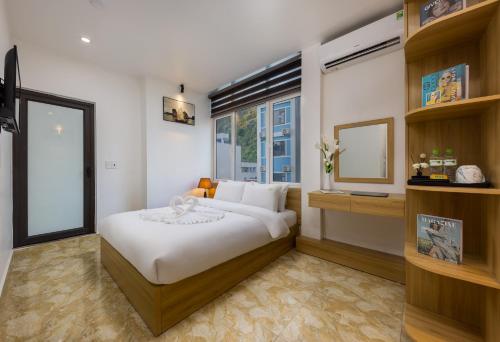 a bedroom with a white bed and a window at Cat Ba Hongkong Hotel in Cat Ba