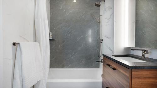 a bathroom with a tub and a sink and a shower at Beautiful Bedroom Suite in Manhattan in New York