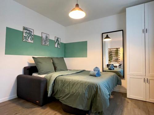 um quarto com uma cama e um espelho grande em Le petit Sartrouville à 20 min de Paris en RER A em Sartrouville
