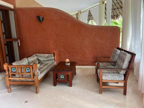 a living room with a couch and two chairs at Beach front villa in Malindi in Malindi