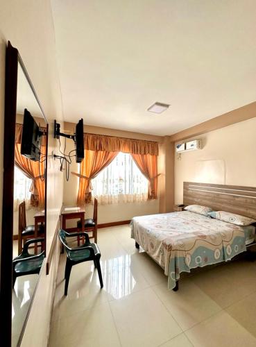 エスメラルダスにあるHotel Zulema Innのベッドと椅子と窓のある寝室