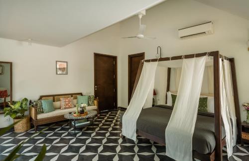a bedroom with a bed and a couch at La Macedo, Luxury 3 BHK Villas in Assagao, with Private Pool, Garden, Terrace, Parking, Security in Mapusa