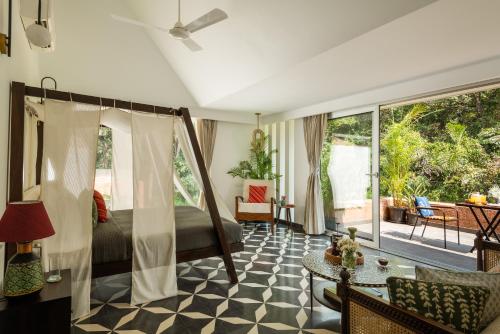 a bedroom with a bed and a living room at La Macedo, Luxury 3 BHK Villas in Assagao, with Private Pool, Garden, Terrace, Parking, Security in Mapusa