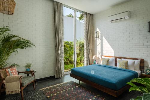 a bedroom with a bed and a large window at La Macedo, Luxury 3 BHK Villas in Assagao, with Private Pool, Garden, Terrace, Parking, Security in Mapusa
