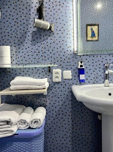 a blue tiled bathroom with a sink and a mirror at FRОDО - Cozy as a home for 4-6 persons in Tashkent
