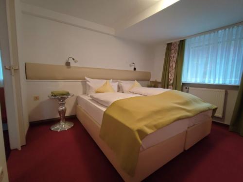 1 dormitorio con 1 cama grande con manta amarilla en Room in BB - Pension Forelle - Doppelzimmer en Forbach