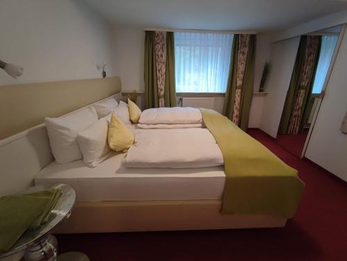 1 dormitorio con 1 cama blanca grande con almohadas amarillas en Room in BB - Pension Forelle - Doppelzimmer en Forbach