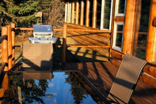 a patio with a glass table and chairs on a deck at Bear Den Vacation Home in Anchor Point