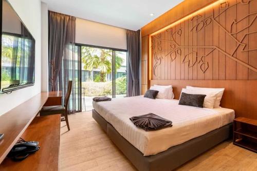 una camera con un grande letto con testiera in legno di Tajh Pool Villas a Chalong