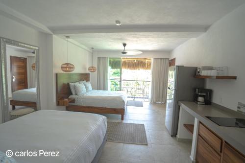 a room with two beds and a kitchen with a kitchen gmaxwell gmaxwell gmaxwell at Hotel Puerto Sayulita in Sayulita